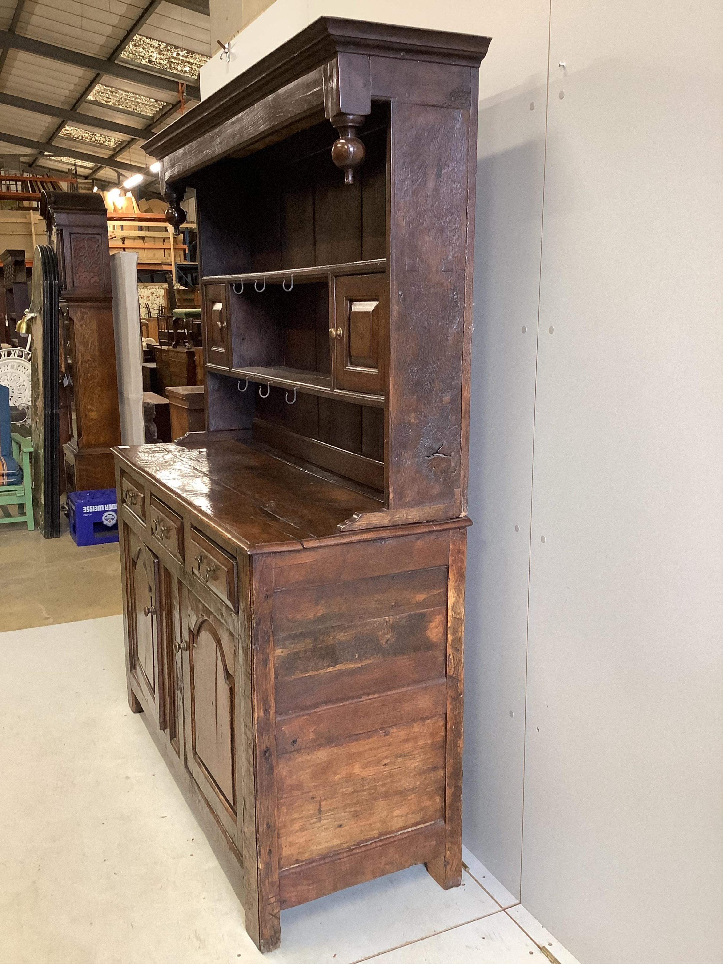 An early 18th century oak dresser, width 142cm, depth 52cm, height 188cm. Condition - fair